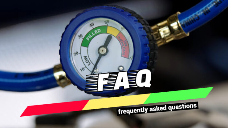 close-up of an air conditioning pressure gauge with a hose attached, set against a blurred background.