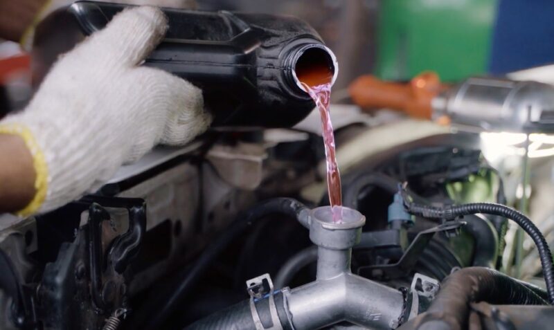 Sipping pink car coolant into car's engine