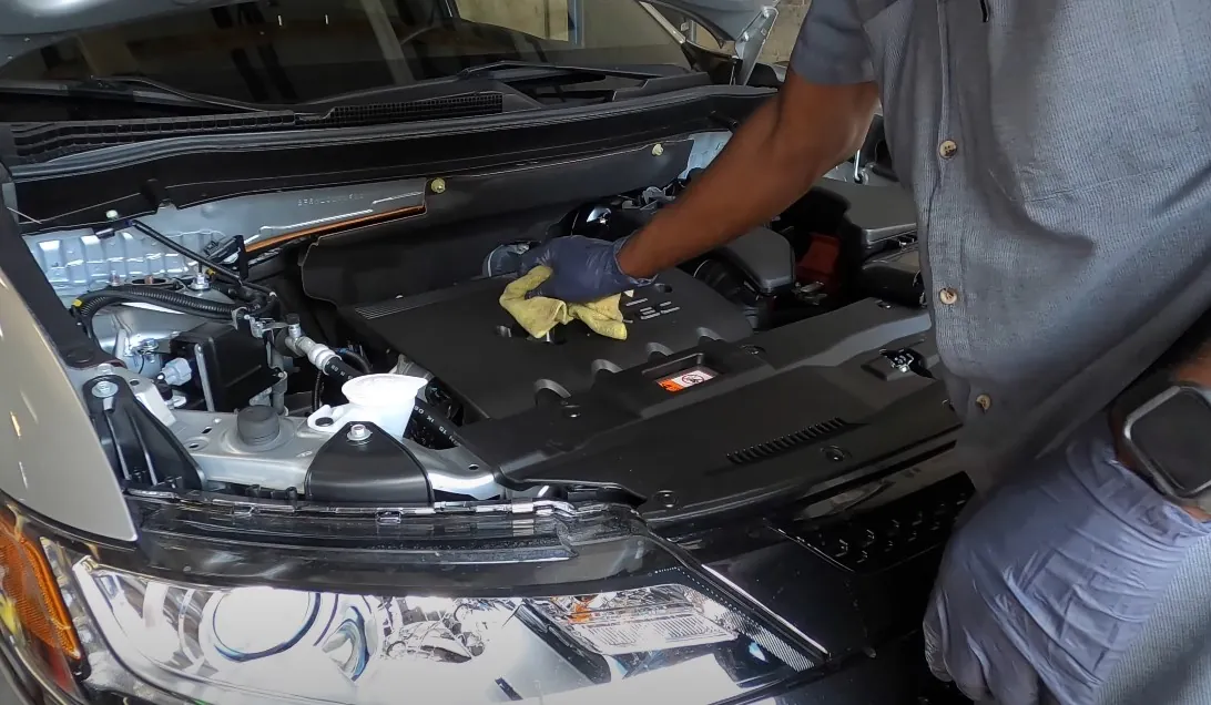 Car mechanic checks Mitsubishi Outlander engine