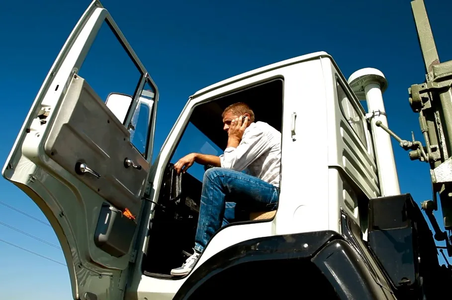 Truck driver speaking on his phone from a truck's cabin