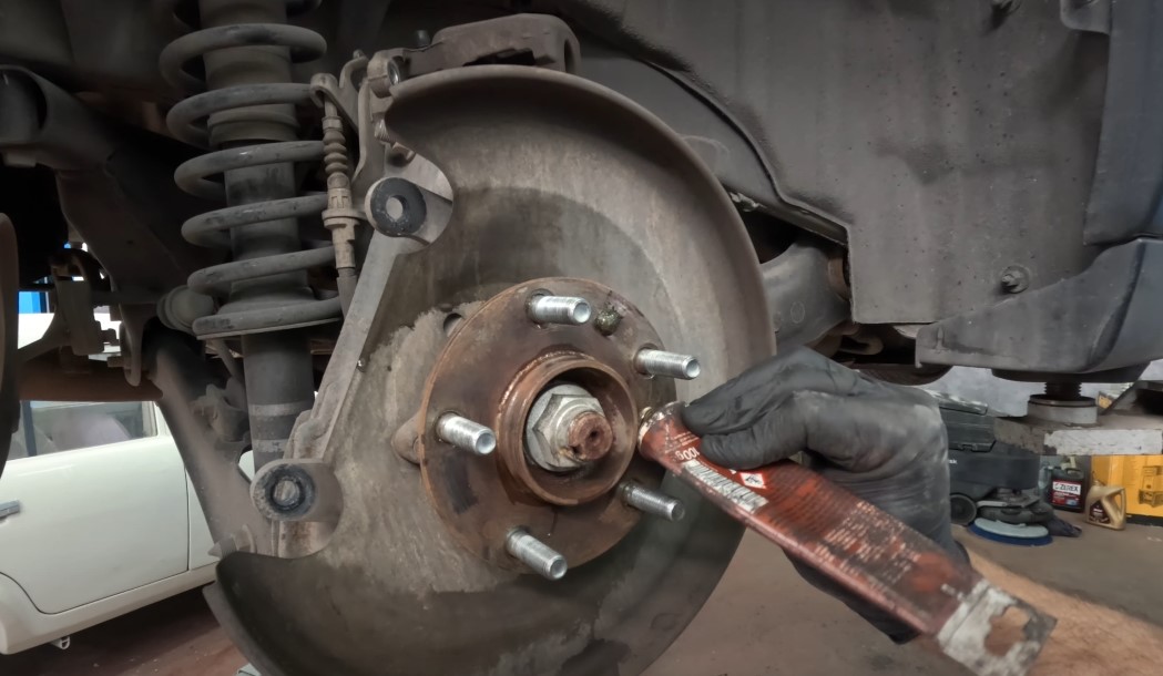 Auto mechanic repairs brakes on Outlander SUV