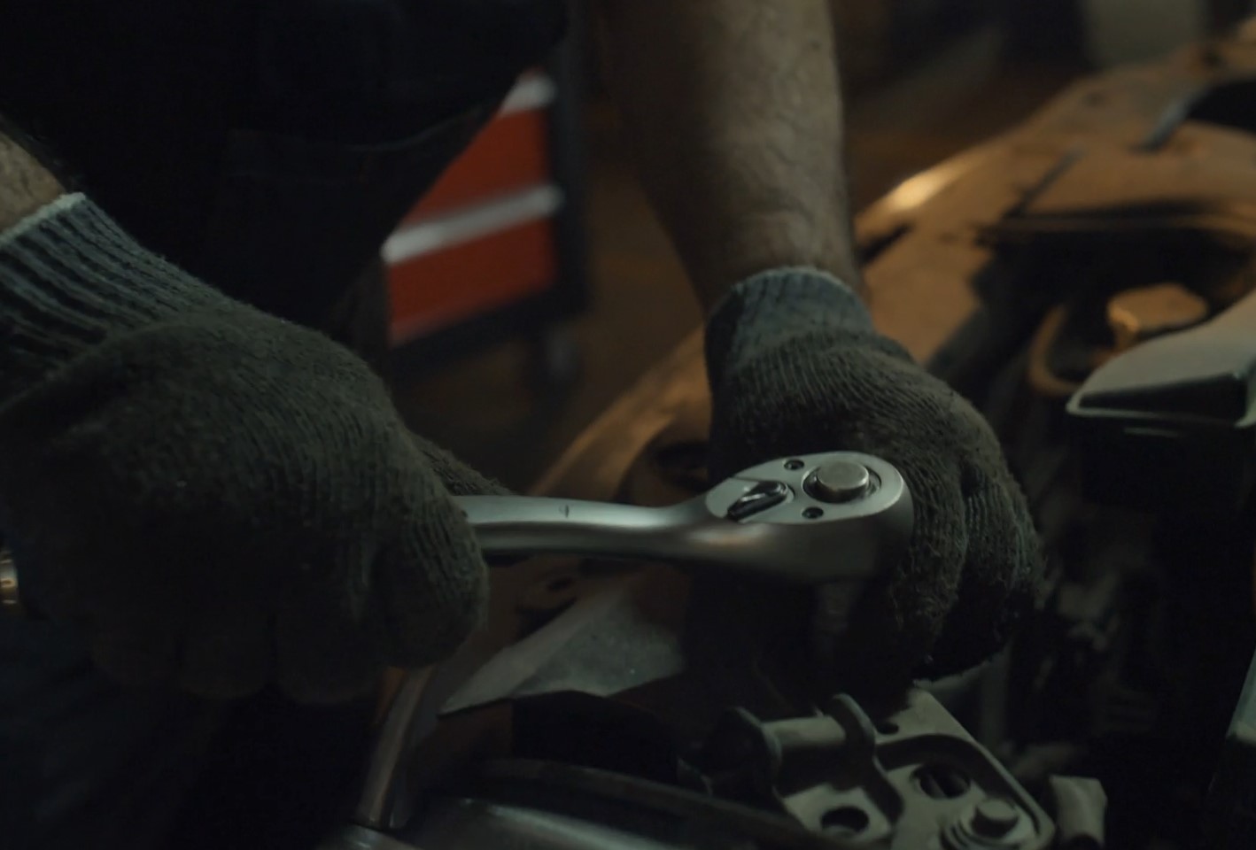 Mechanic repairs car using a wrench