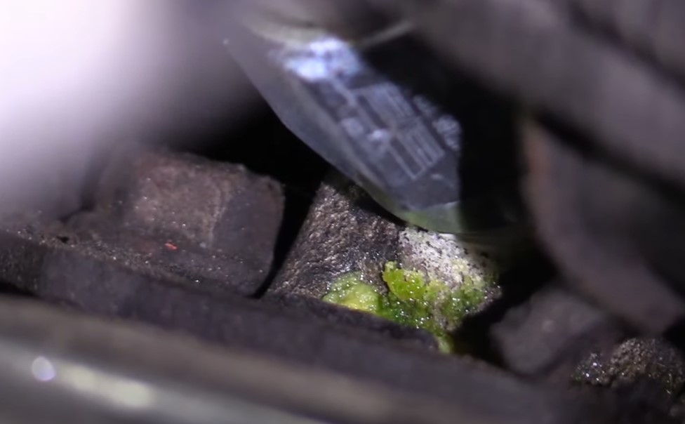 Close up photo of green coolant leaking inside a car