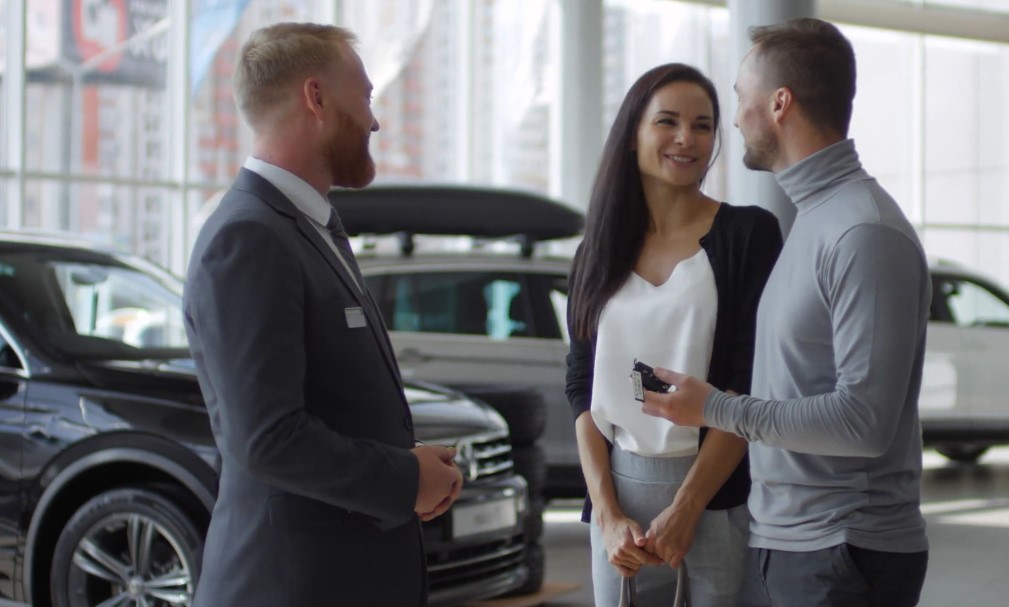 Young couple buying car in a showroom