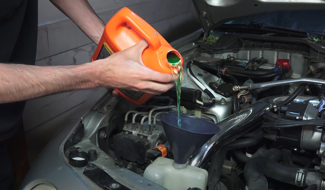 Mechanic sips coolant in a car