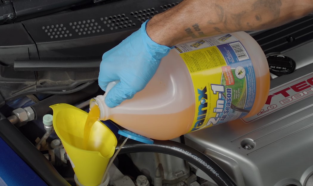 Mechanic sips coolant in engine