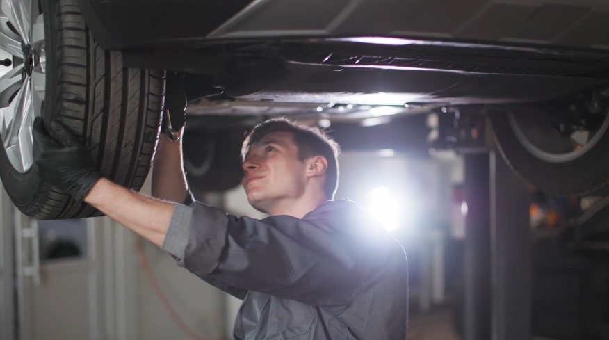 Skilled mechanic meticulously working under a lifted vehicle