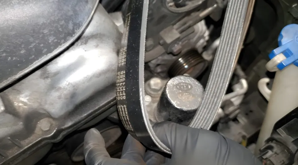 Close-up view of a serpentine belt and engine components