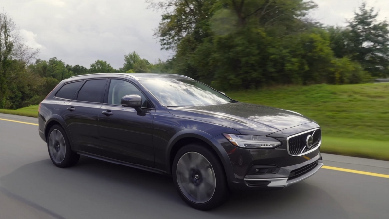 Dark-Colored Volvo Car Driving on A Road Surrounded by Greenery