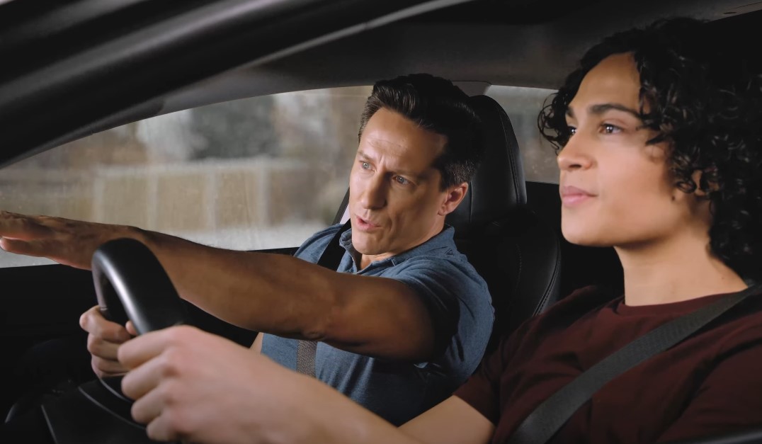 A father guides his teenage son through the process of learning to drive