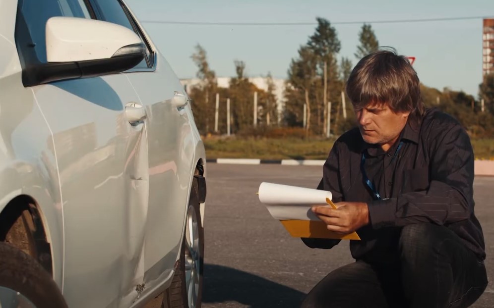 A professional examines the vehicle's exterior damage