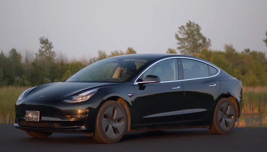 Black Tesla Model 3 parked next to the road