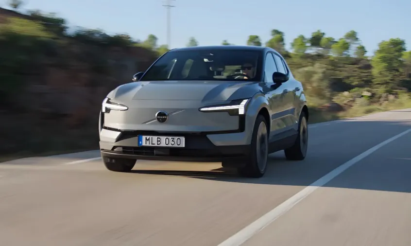 Modern Volvo SUV gliding effortlessly down a sun-drenched road