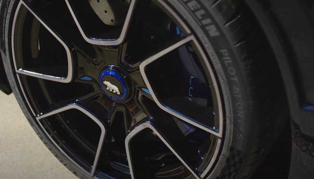 A close-up of a black car's wheel featuring striking blue rims