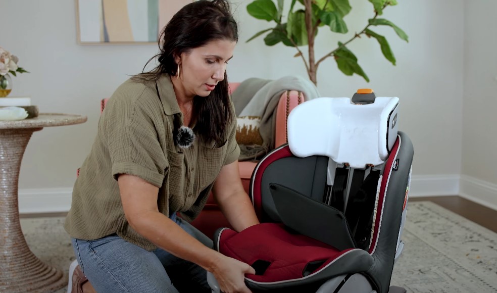 Woman carefully adjusts the child car seat