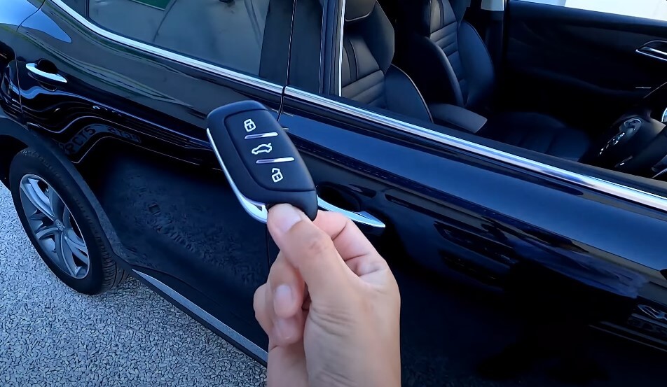 A modern key fob, sleek and sophisticated, held in a hand