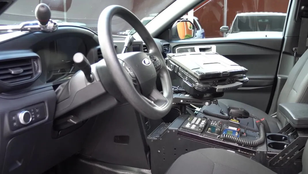 Modern police vehicle interior, equipped with a specialized console and laptop