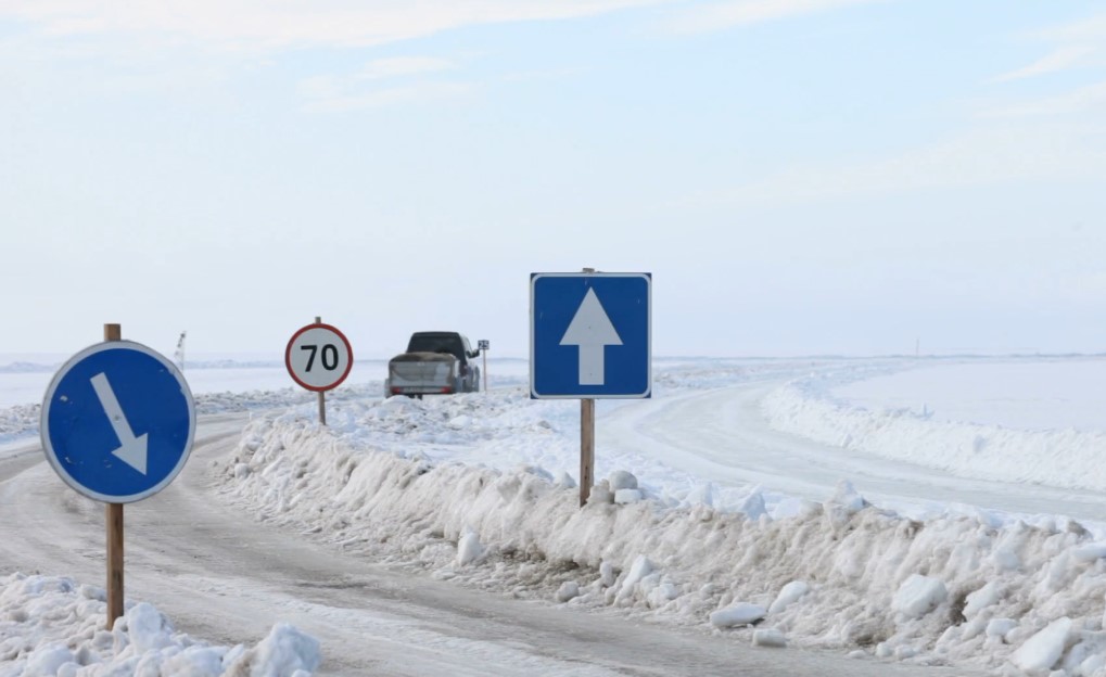 A snowy road winds through a vast expanse of white