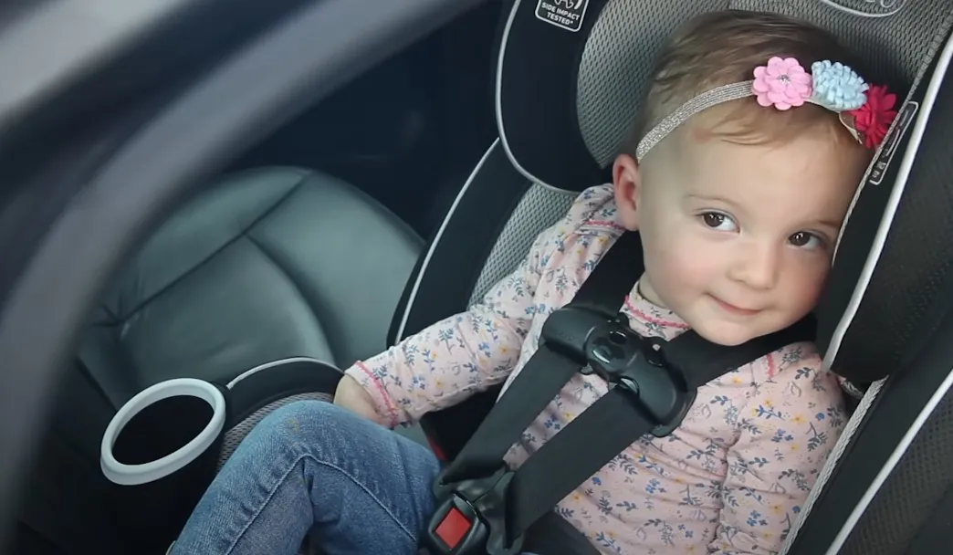 A sweet toddler safely secured in their car seat