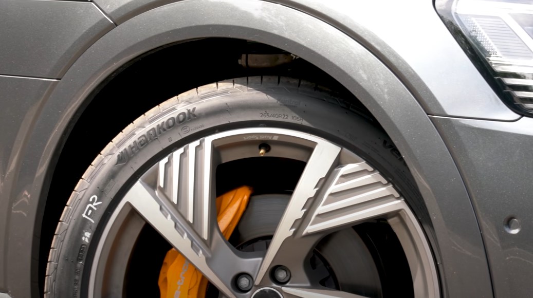  close-up view of a car tire showcasing vibrant orange brake pads