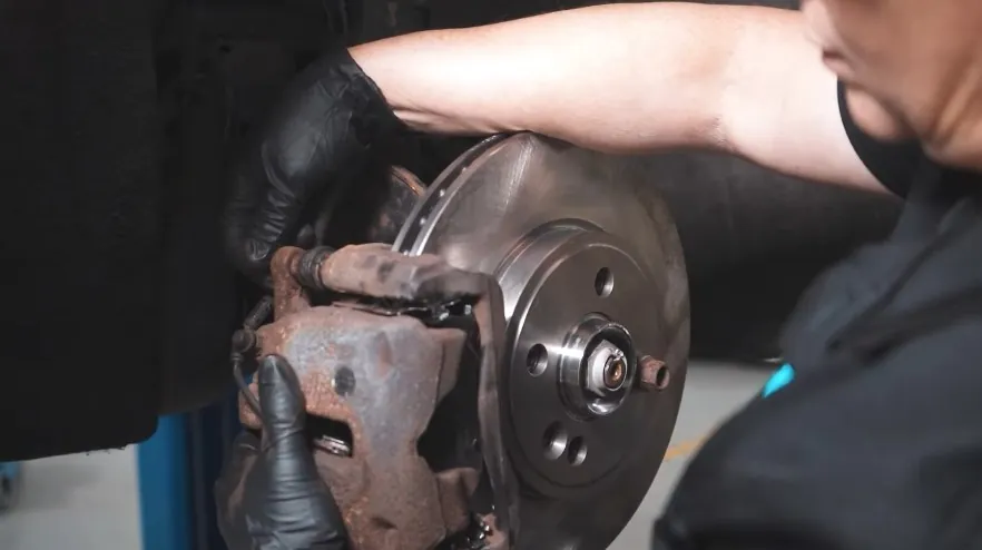 A mechanic meticulously works on a vehicle's brake system