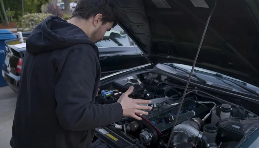 A person examines a meticulously maintained engine bay