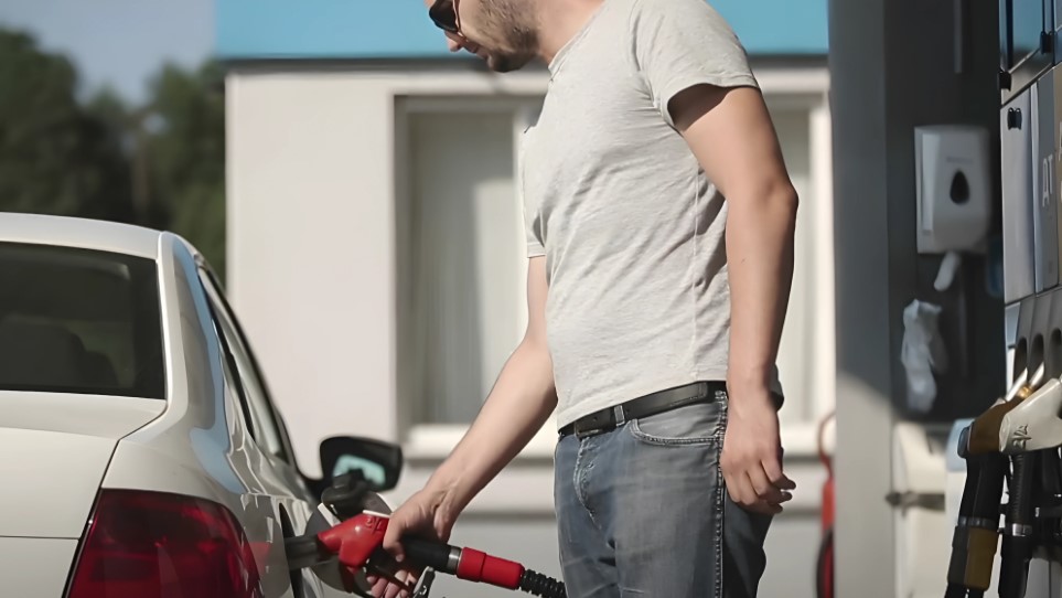 Man fueling his car at a gas station