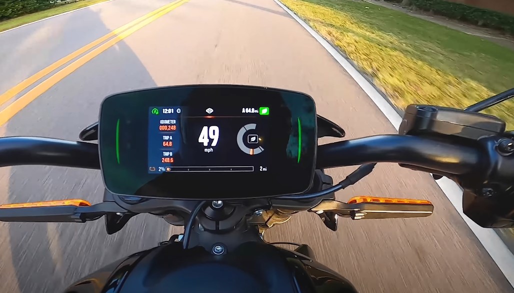 A motorcycle dashboard displays 49 mph, indicating a steady pace on the open road