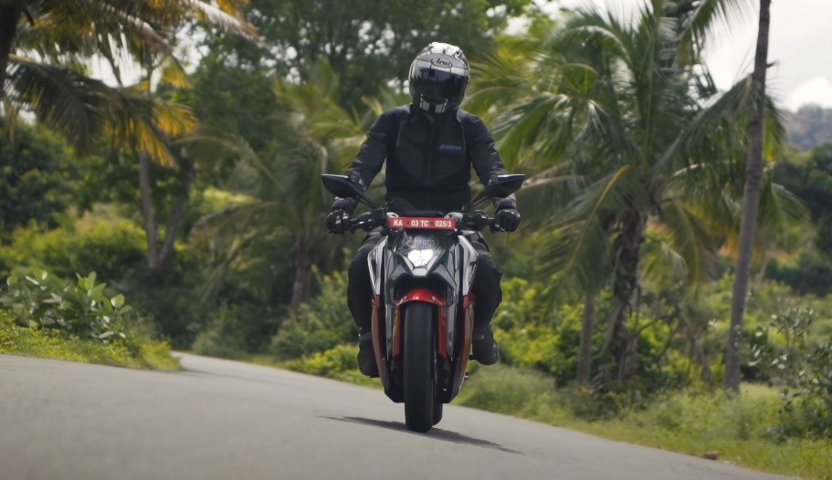 Motorcyclist navigating a scenic, winding road through lush tropical foliage