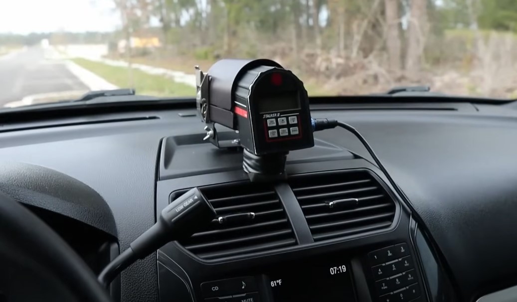 A black radar detector mounted on a vehicle's dashboard