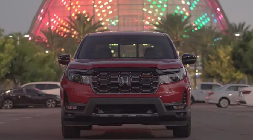 The Honda Ridgeline's bold profile is highlighted by the city lights