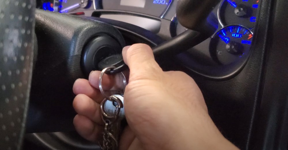 A person turning car key, close up view