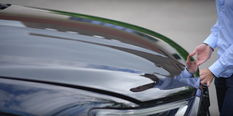 A person lifting the car hood due to dead battery