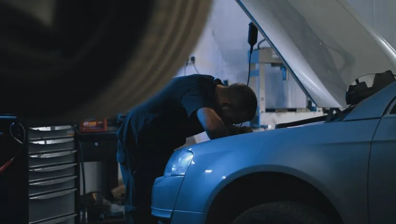 Mechanic repairing a car under the hood