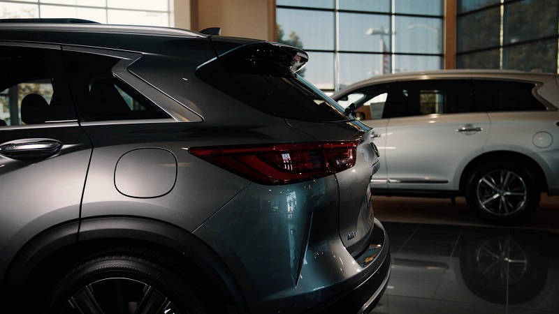 Close-up of two SUVs in a car dealership showroom with natural light coming through large windows