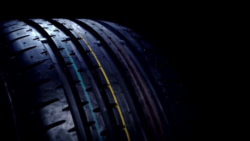 Close-up of a tire tread pattern with visible colored lines from different tire brands