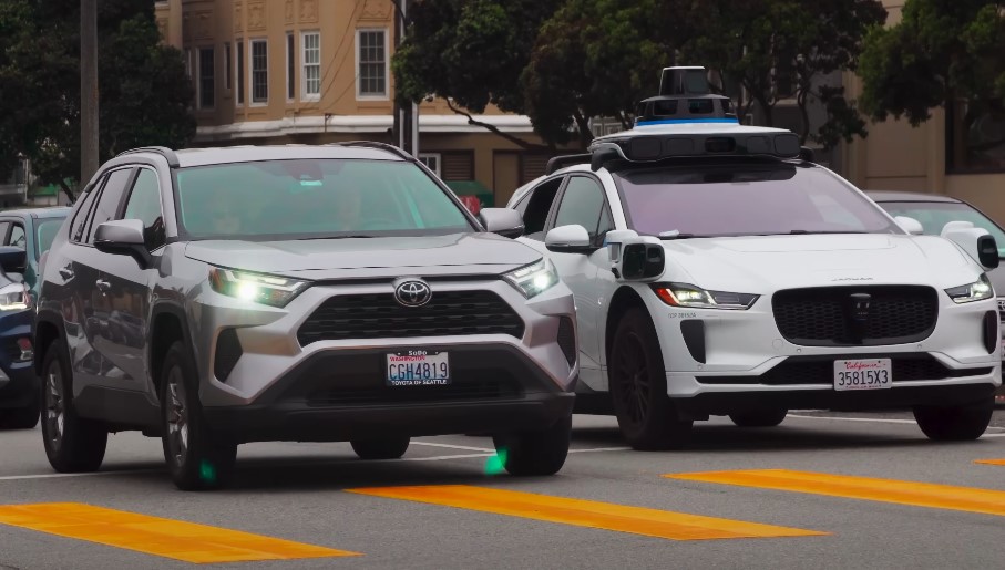 Autonomous vehicle technology coexists with traditional vehicles on a city thoroughfare