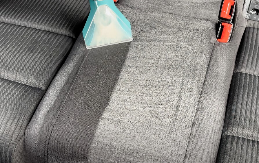 A specialized vacuum cleaner meticulously cleans car seats