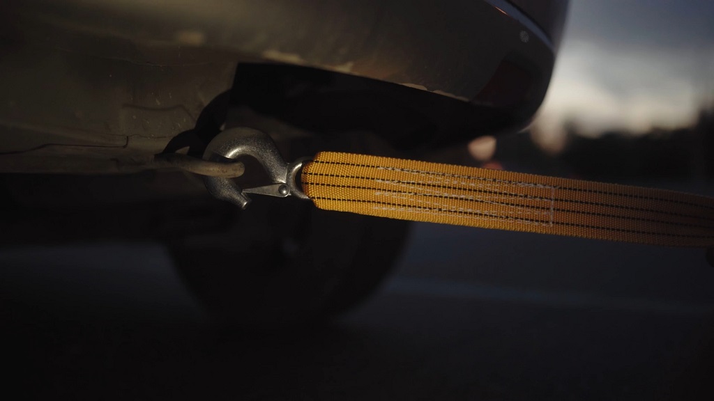 Close-up of a tow strap hooked to a car, highlighting why EVs with a dead battery require special towing techniques