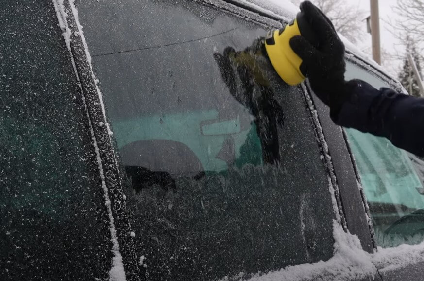 A frosty morning task. Clearing ice from a car window