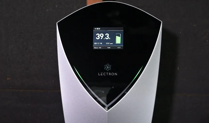 Sleek, modern EV charging station with a digital display showing current time, power level, and charging status