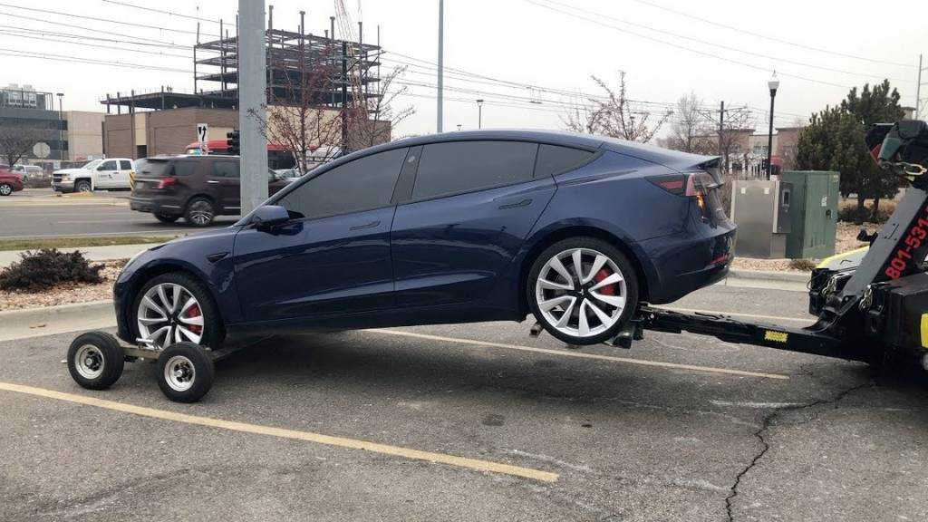 Electric vehicle being safely towed, using specialized equipment
