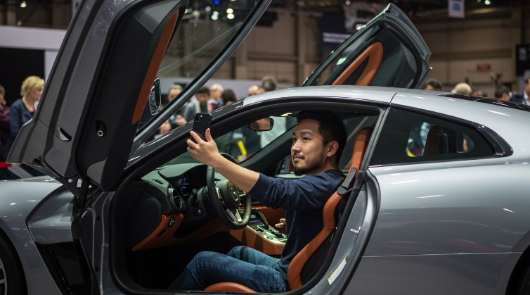 Happy man inside a car, capturing the moment at a car show