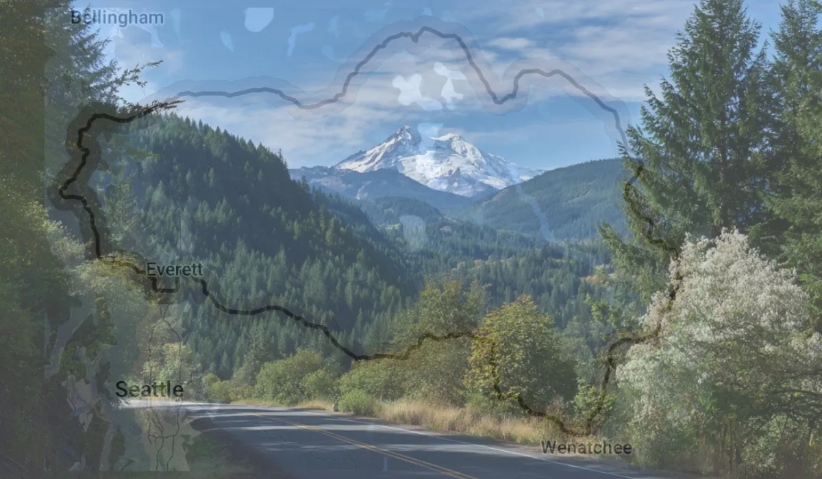Scenic mountain highway with a transparent map overlay of the Cascade Loop route in Washington State