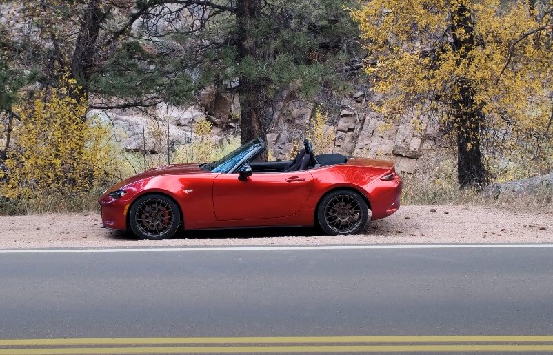 Red Mazda Miata parked next to the road