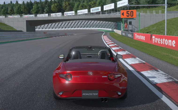 A red Mazda Miata navigates a winding race track in Gran Turismo game