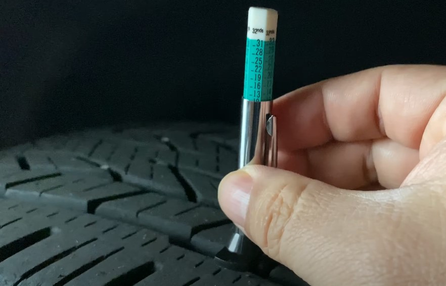 A close up view of a tire tread depth gauge