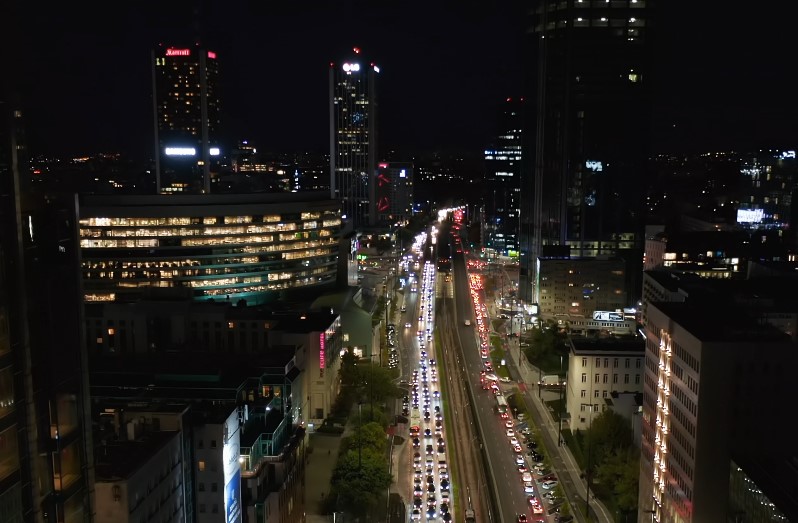 A sprawling cityscape at night, illuminated by the glow of countless windows and headlights