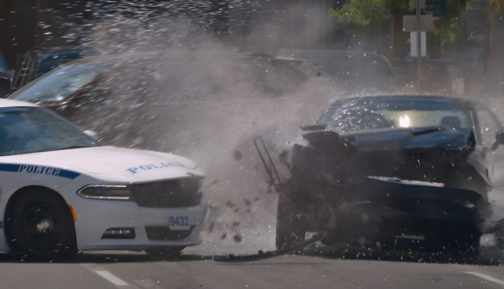 A high-impact collision, with a police cruiser and another vehicle, sending water and debris flying