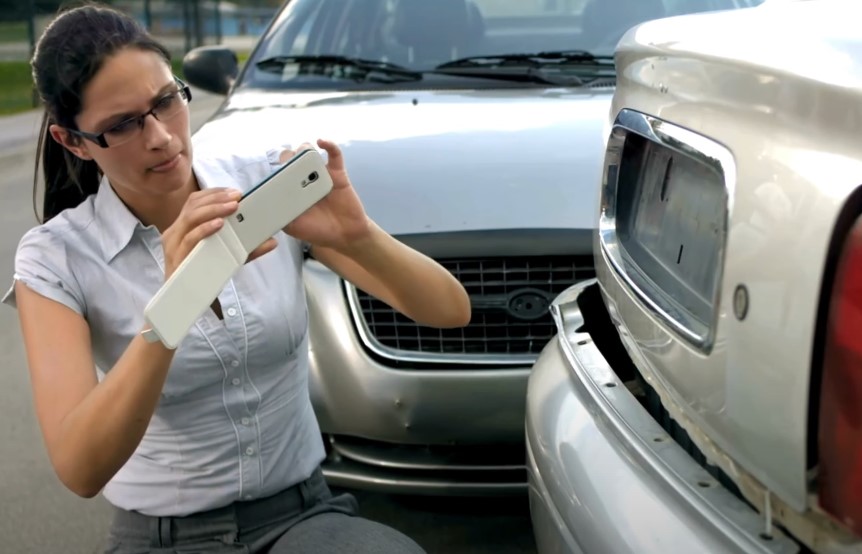 Woman documents car damage with a smartphone